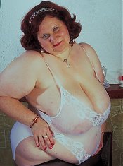 This chunky older babe with a massive set of knockers loosens her negligee to play with her bazooms